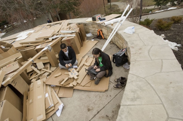 People sitting near cardboard
