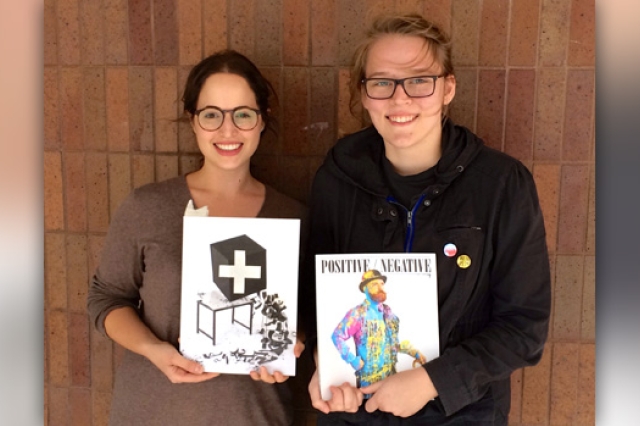 Tow people holding magazines