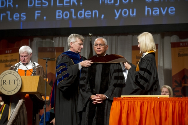 People fixing suit on stage