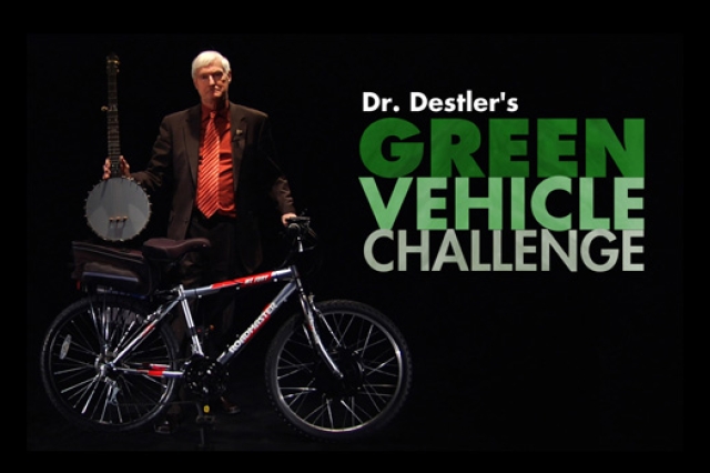 graphic of President Destler holding a banjo and bike with the text: Dr. Destler's Green Vehicle Challenge.