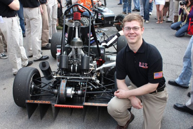 Person posing in front of vehicle