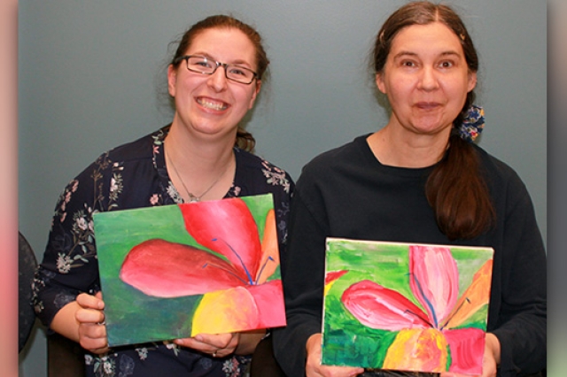 Artists posing for camera with painting