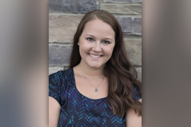 Person posing for camera in front of wall