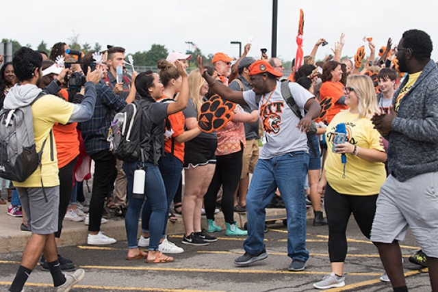 Group of students celebrating in parking lot at convocation.