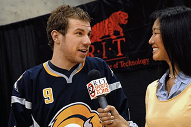 Hockey player answering questions for reporter