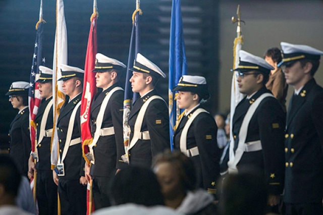 Uniformed people lined up with flags