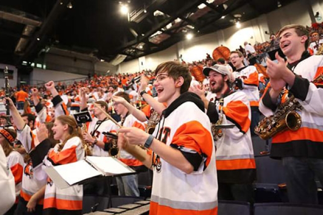 Elise Walsh with RIT Pep band all dressed in RIT Jerseys.