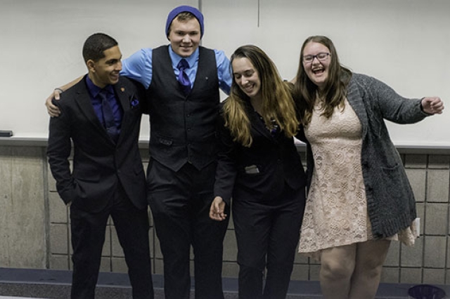 Four members of Alpha Phi Omega Xi Zeta chapter dressed up posing for picture.