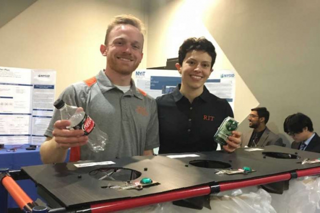 Two students pose with recycling sorter.