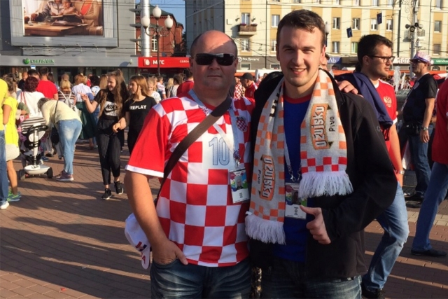 Two men posing for a camera in front of a crowd