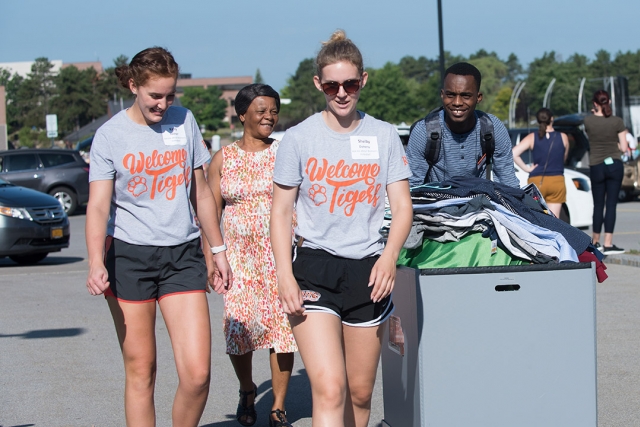 Students and parents bring items in cart for move-in day.