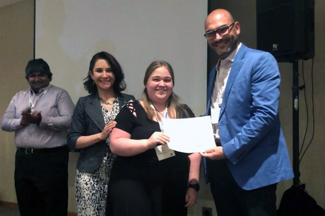 Student receives award while standing with professor.