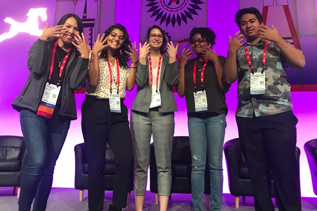 group of 5 students does the American Sign Language sign for "tiger"