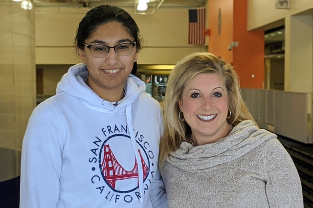 student and staff member standing side-by-side.