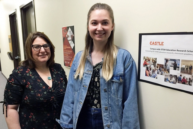 two women standing in hallway.