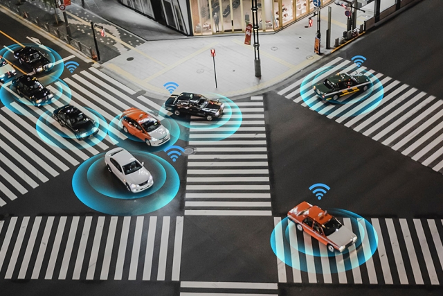 cars at an intersection with WiFi signals above them.