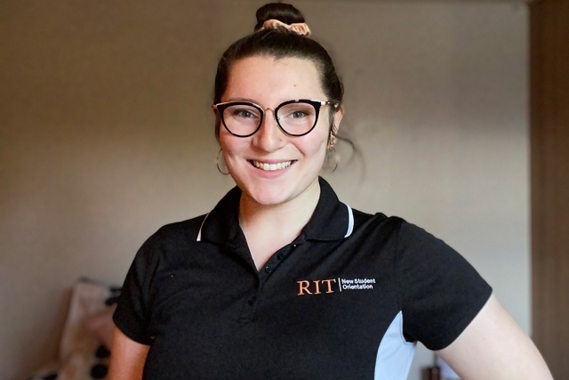 student wearing RIT New Student Orientation polo shirt.