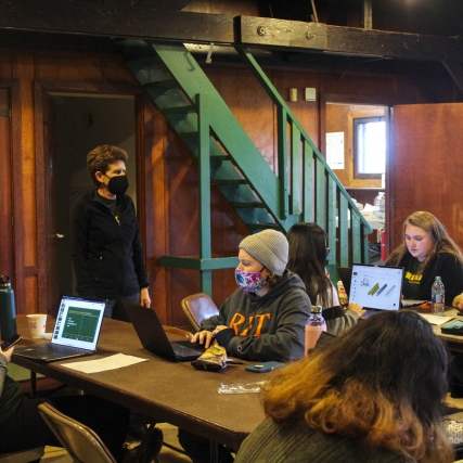 Students work on computers in a park lodge.