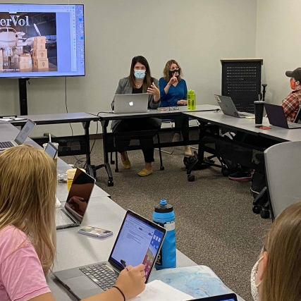 A speaker gives a presentation to a class. 
