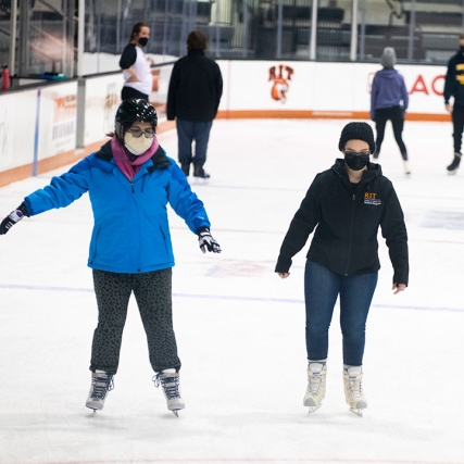 students ice skating in the Gene Polisseni Center.