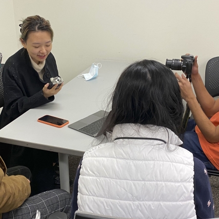 Students hover around a table.