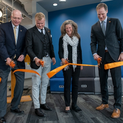 four people cutting a ceremonial ribbon.