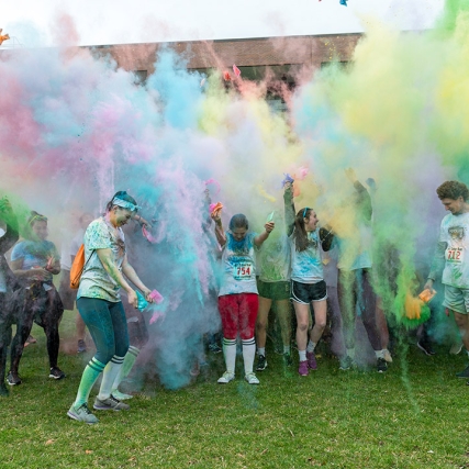 students in a race throwing colored power in the air.