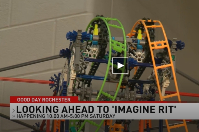 A close-up shot of a colorful miniature roller coaster ride with text overlaid that says "GOOD DAY ROCHESTER, LOOKING AHEAD TO 'IMAGINE 'RIT' HAPPENING 10:00 AM-5:00 PM SATURDAY