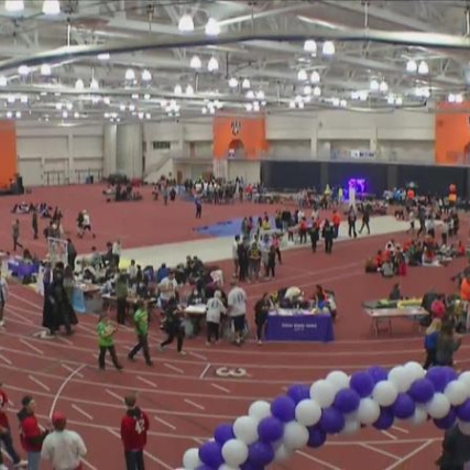 people participating in a walking relay in a field house.