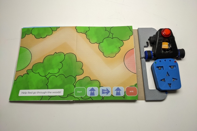 An overhead view of Storybook Robotics, a storybook paired with a robot to also teach kids coding.