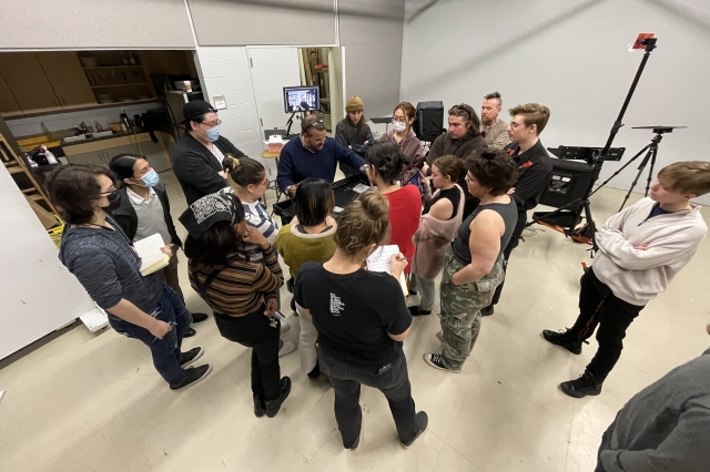 A group of students and instructors look at high-tech studio photography equipment.