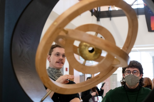 two people looking at a sculpture with three concentric circles.