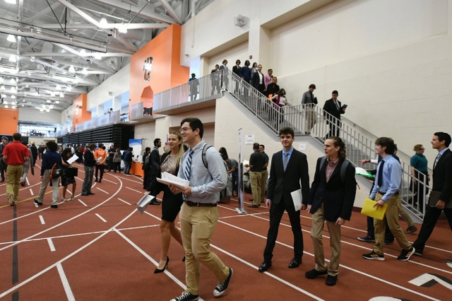 students walking into a field house for a career fair.
