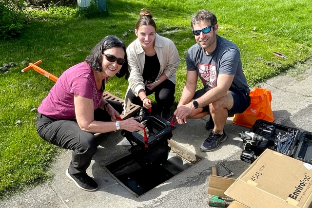 Three people pose around a Littatrap.