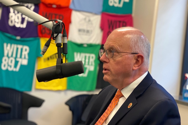 R I T president Munson talking into a radio station microphone.