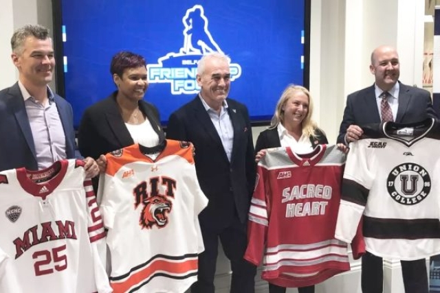 Five people stand holding four different hockey jerseys. Jerseys include Miami, RIT, Sacred Heart, and Union College.