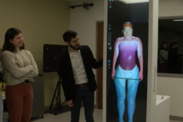 a professor shows off a digital anatomy table to students in a lab.
