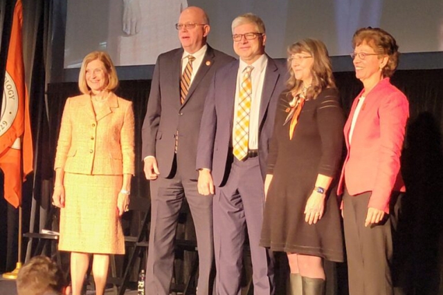 RIT board members and current president stand on stage with newly announced president and his wife