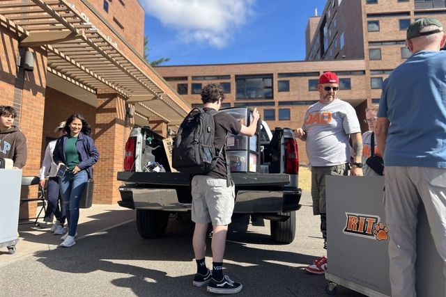 students and parents unload a truck on R I T move in day.