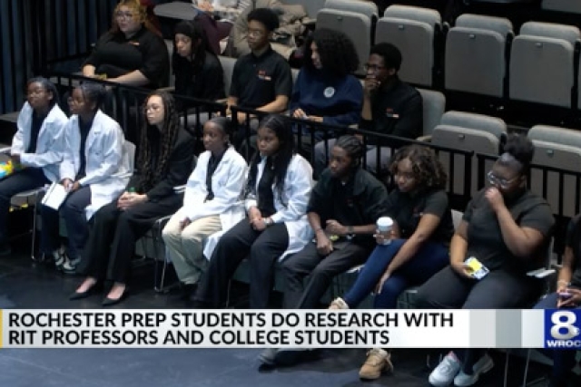 College prep students sit in a row at a presentations.
