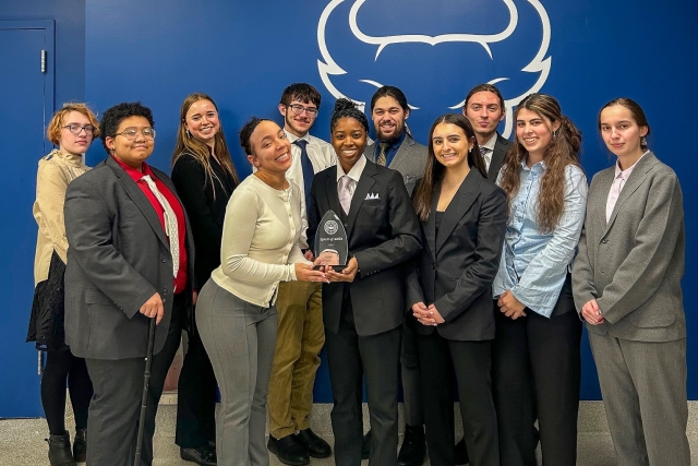 Group of student standing, holding an award