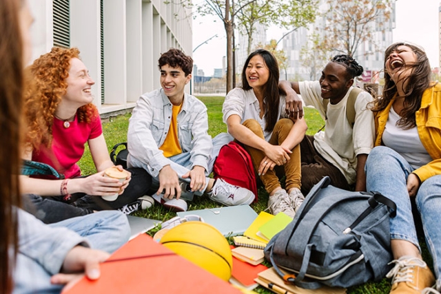 students sitting outside in a college setting.