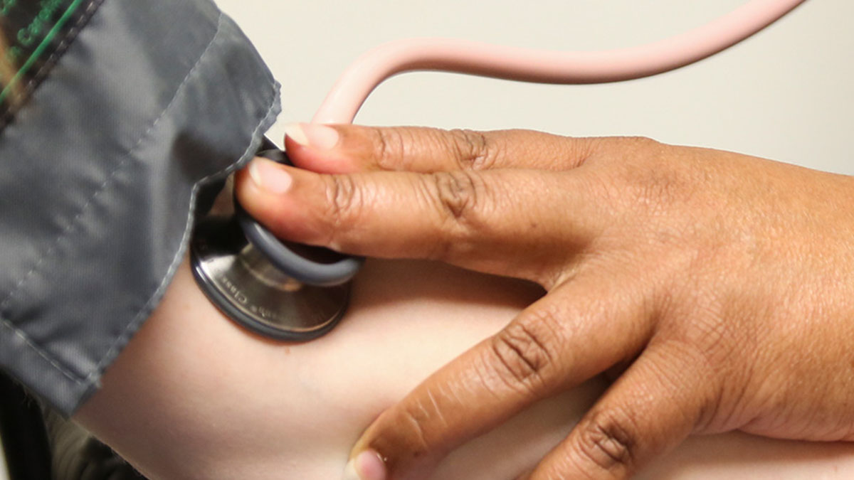 Closeup of a medical professional taking a person's blood pressure.