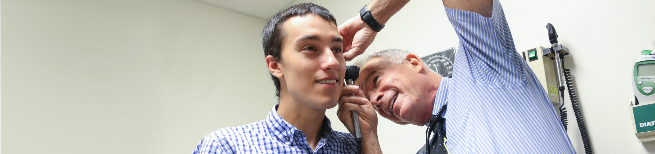 A medical professional examining a person's ear.