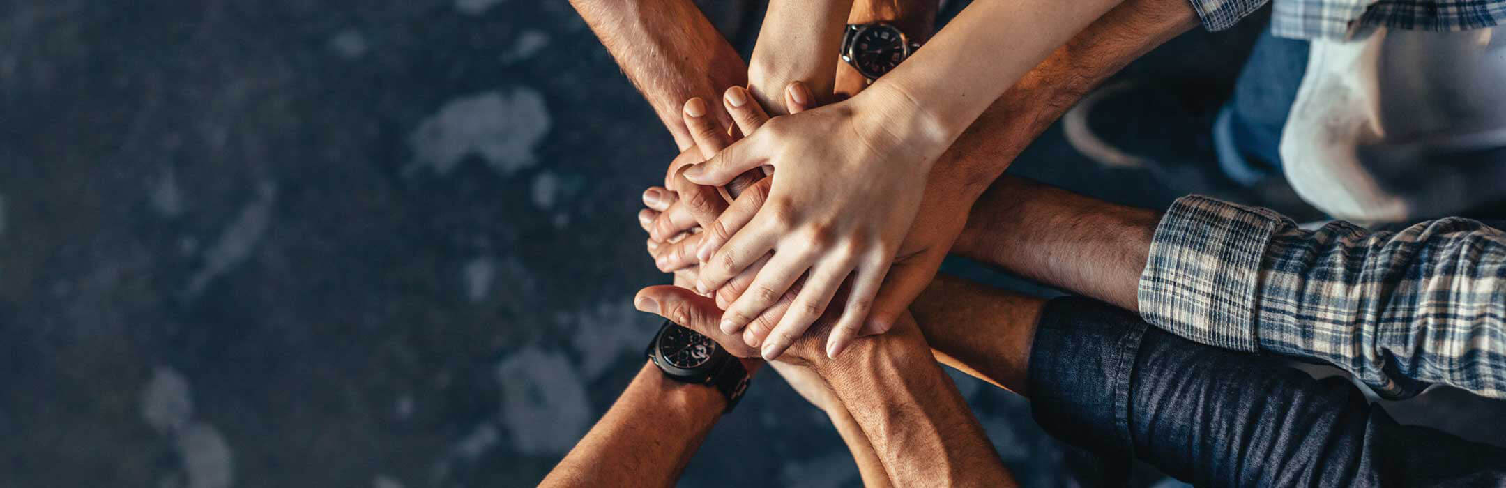 An overhead shot of several hands on top of each other