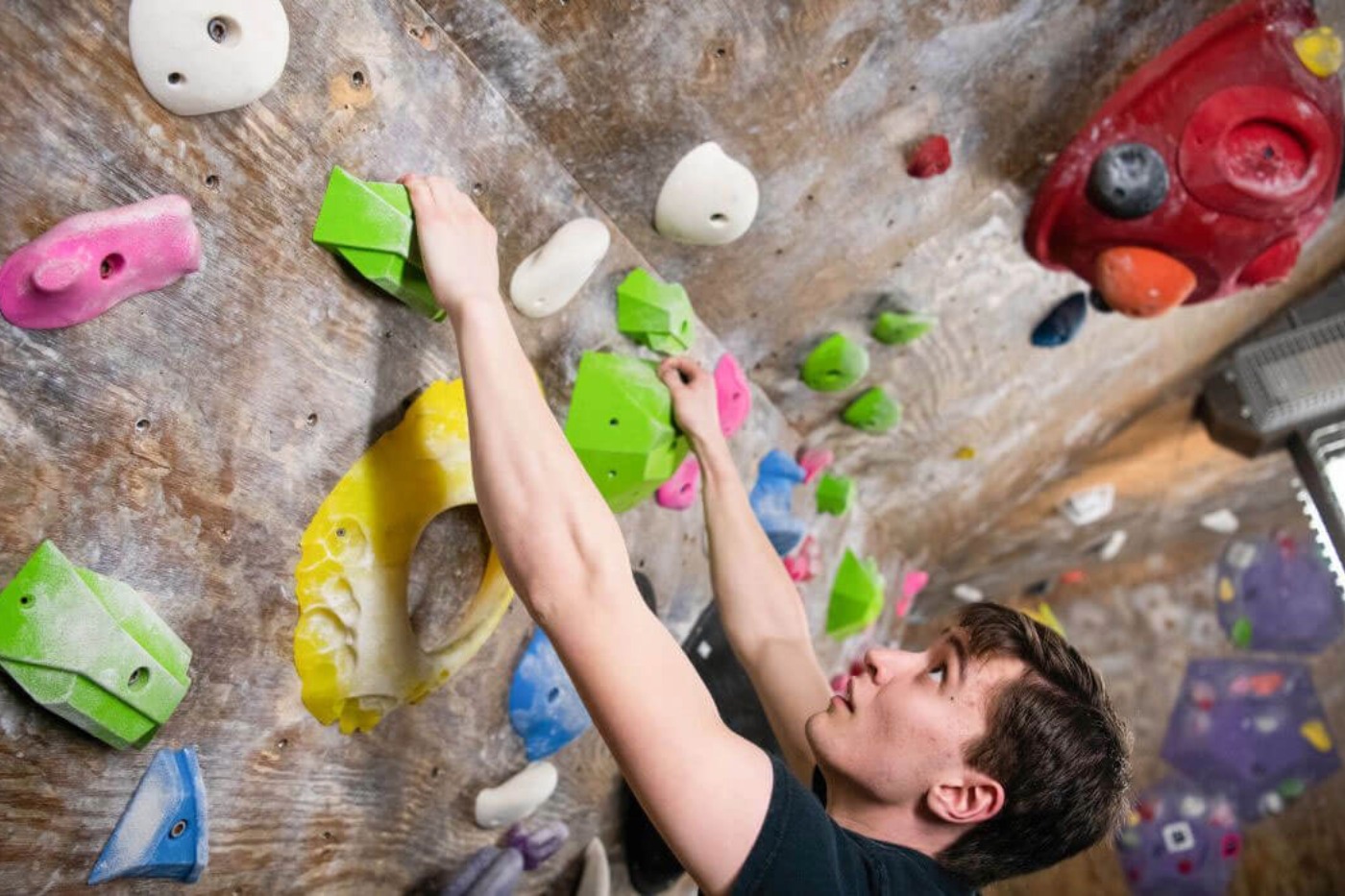 A student close up climbing at the Red Barn Climbing gym 