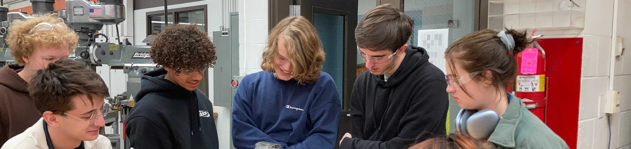 students smiling as the work in a lab on a project