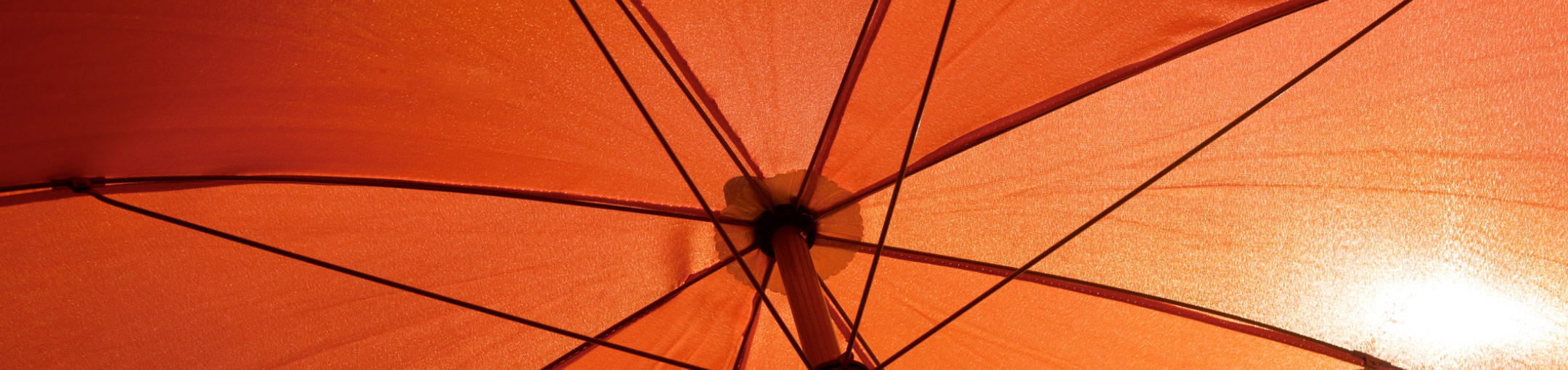 The inside of an opened orange umbrella