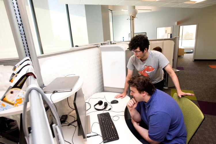 Two RIT Students looking at a computer in a lab together