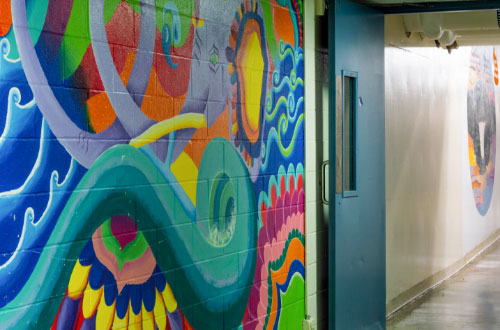An image of a mural, with colorful non-sensical colorful shapes, in the tunnel.